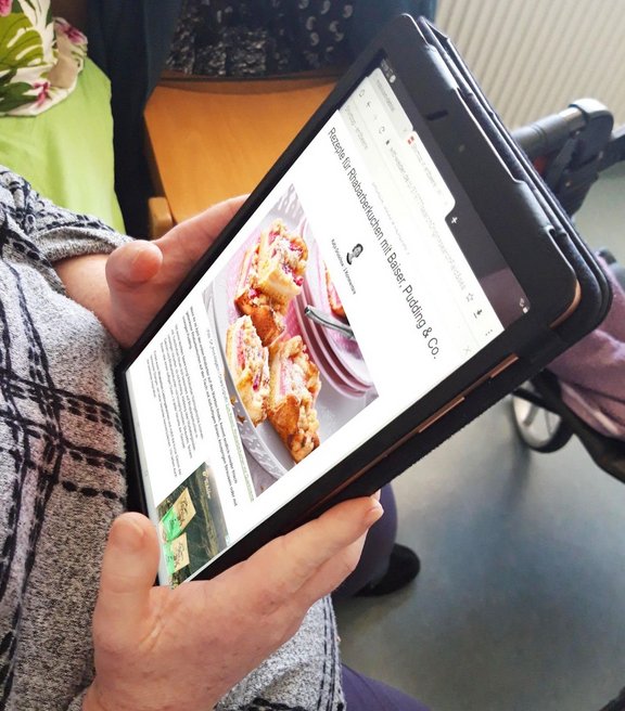 Person sieht sich ein Rezept auf dem Tablet an