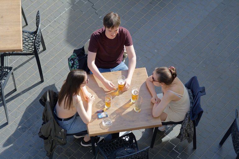 Drei Jugendliche trinken Bier am Tisch in einem Restaurant 
