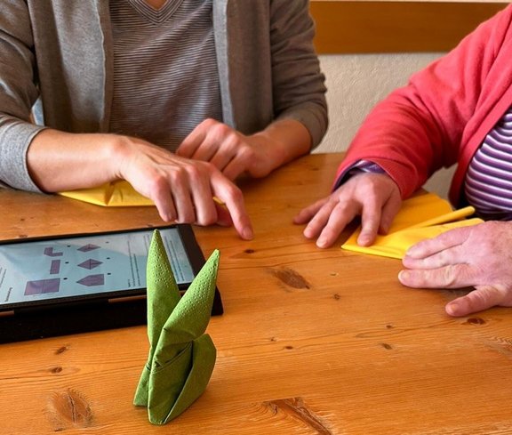 Servietten falten nach Anleitung auf Tablet
