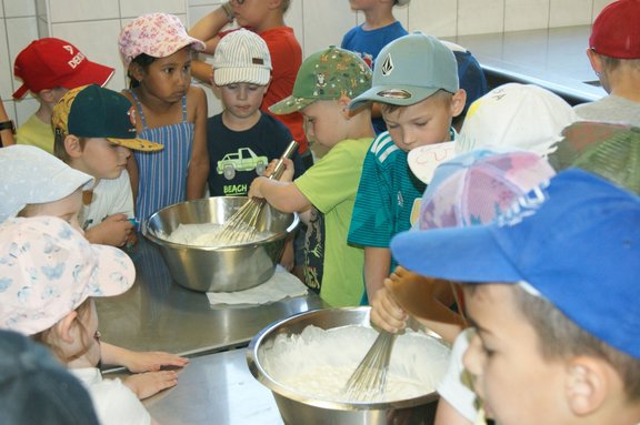 Kinder rühren in zwei Schüsseln mit Joghurt