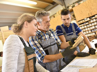 Zwei Auszubildende mit Schreiner-Meister 